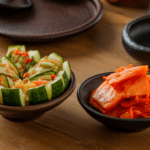 Side-by-side comparison of Oi Sobagi and Oi Kimchi, showcasing their distinct textures and colors on a traditional Korean table setting